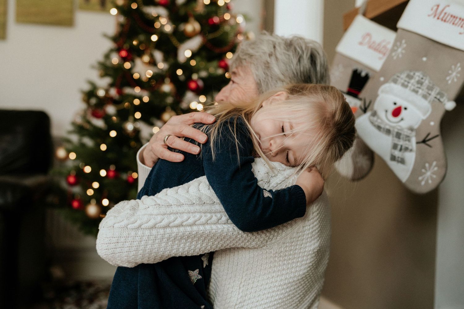 Festive Christmas scenes with decorated tree and cosy white sweater details in warm indoor lighting.