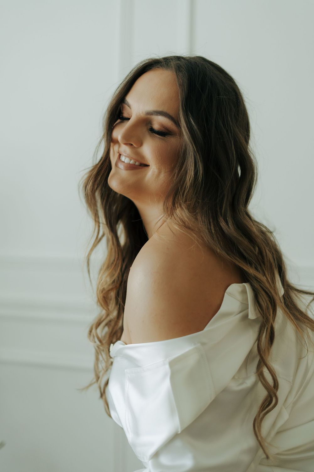 A series of four artistic photos showing someone in a white top with flowing hair against a light background.