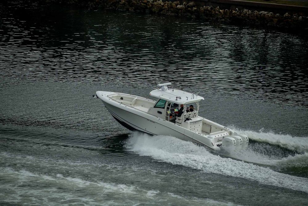 Multiple white speedboats racing across dark waters creating dramatic wakes behind them.