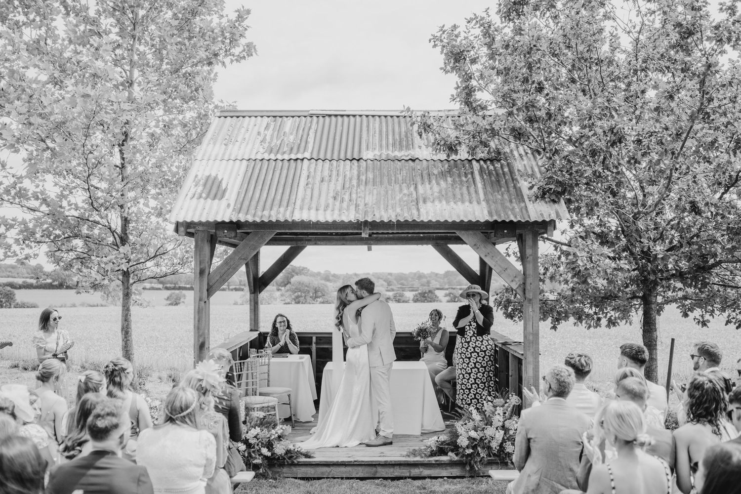 Wedding guests enjoying wine and conversation at an elegant reception in black and white photography.