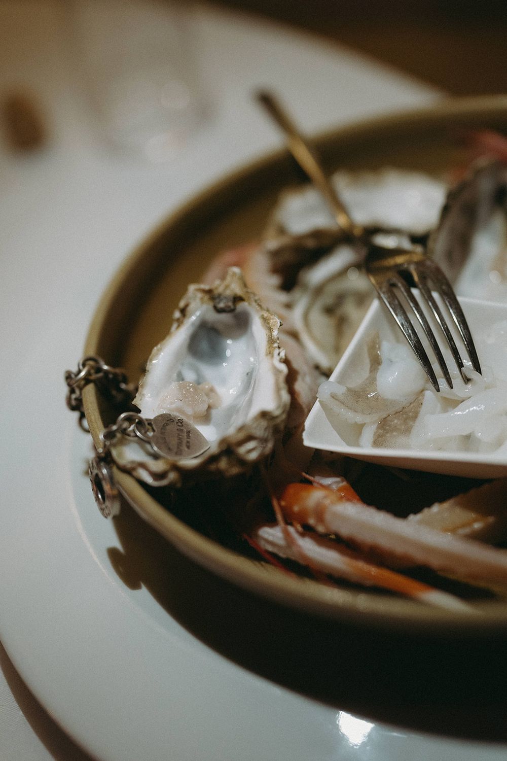 Close-up macro shots of a silver fork on a dark plate with reflective surfaces creating an abstract composition.