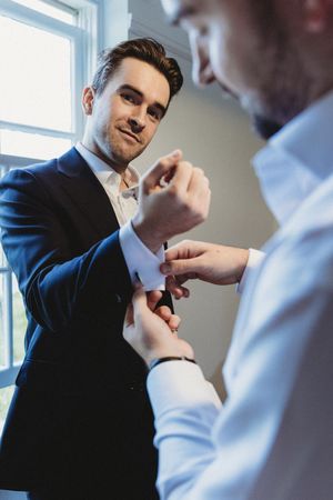 Best man helping Groom with cufflinks at Henham Barns