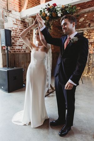 Bride and Groom raise their hands in celebration at Henham Barns