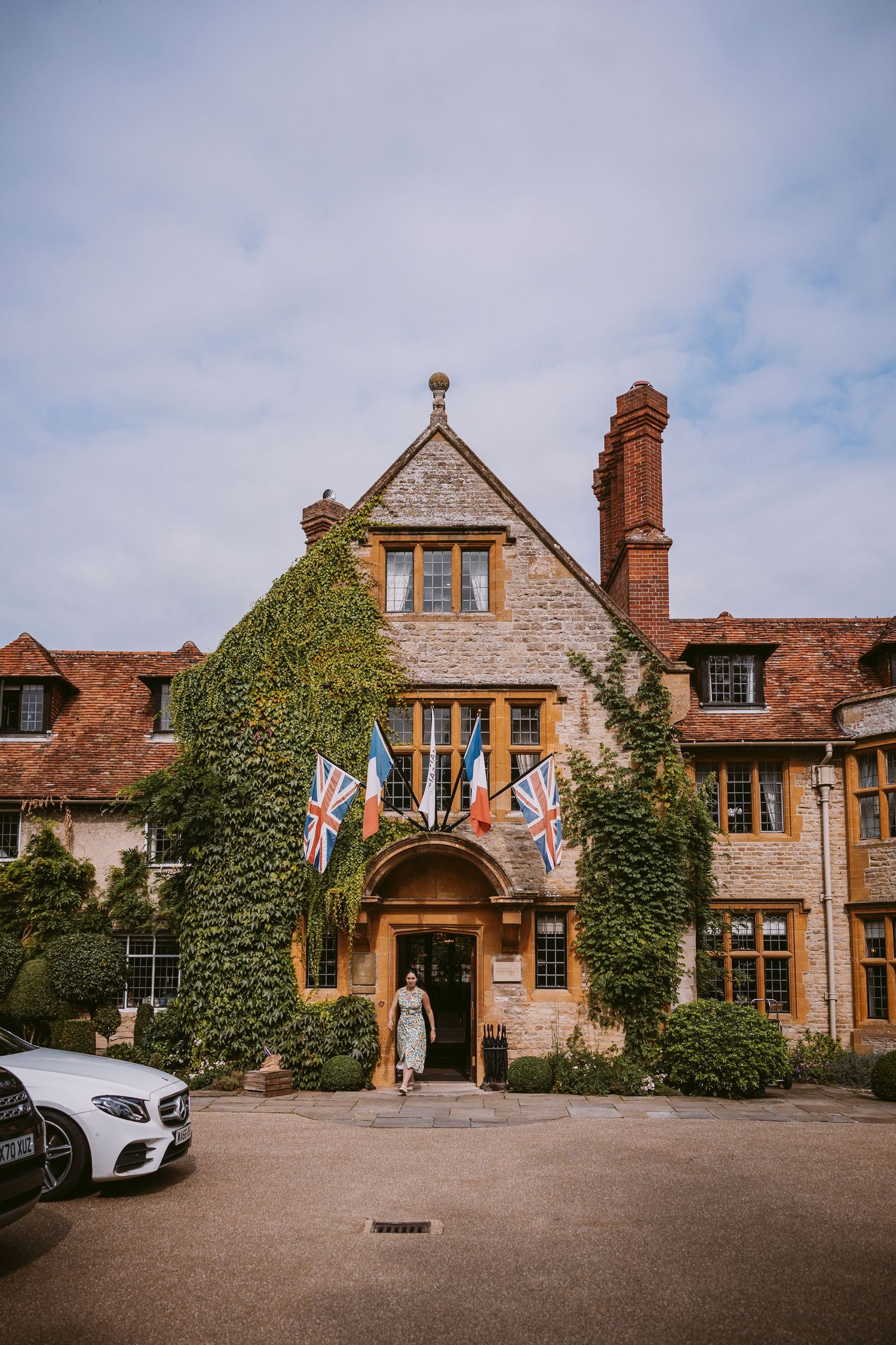 Historic stone manor house with ivy-covered walls and Tudor-style architecture showcases multiple views of its elegant exterior.