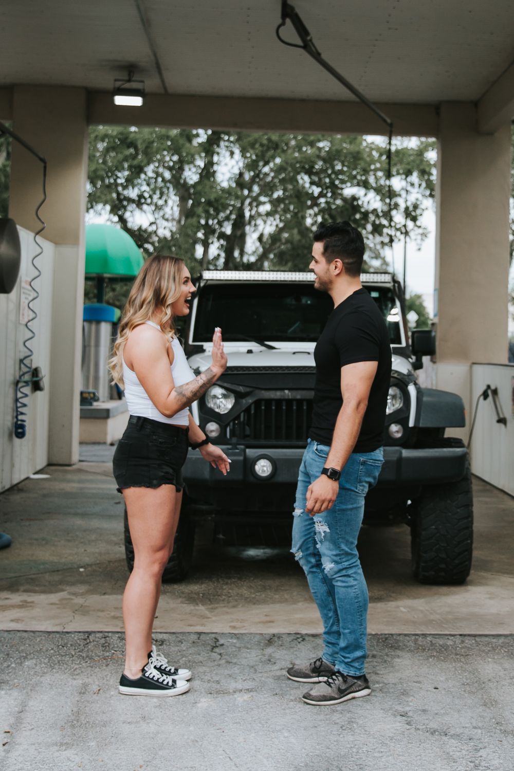 Series of candid shots showing a couple interacting near a parked black vehicle under a covered area.