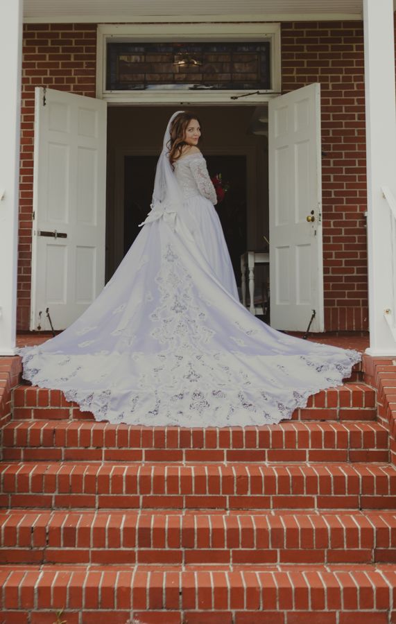 bride dress in a white dress fanned out on the church steps