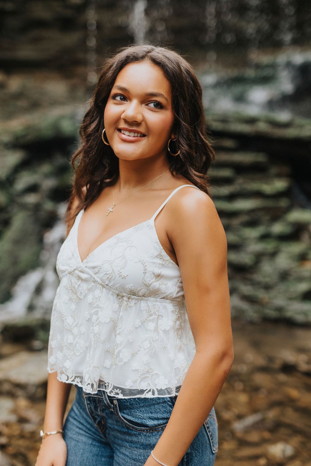 A series of outdoor portrait photos showing someone in a white lace camisole top and denim against a rocky natural backdrop.