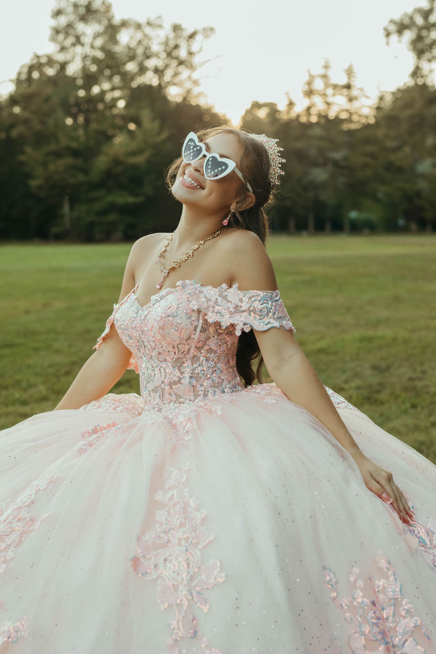 Elegant white and pink princess ball gown photographed in a sunlit field.