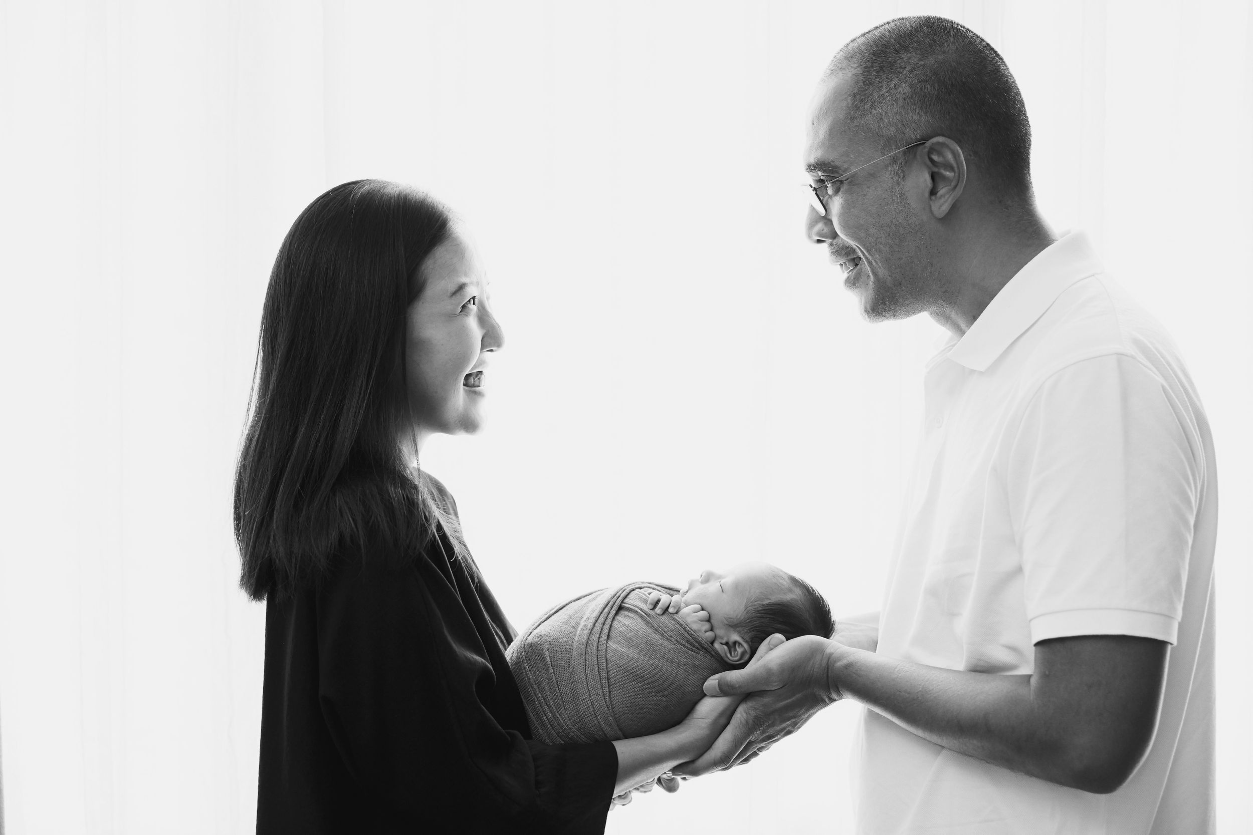 Family portrait series against white background showing tender moments with newborn.