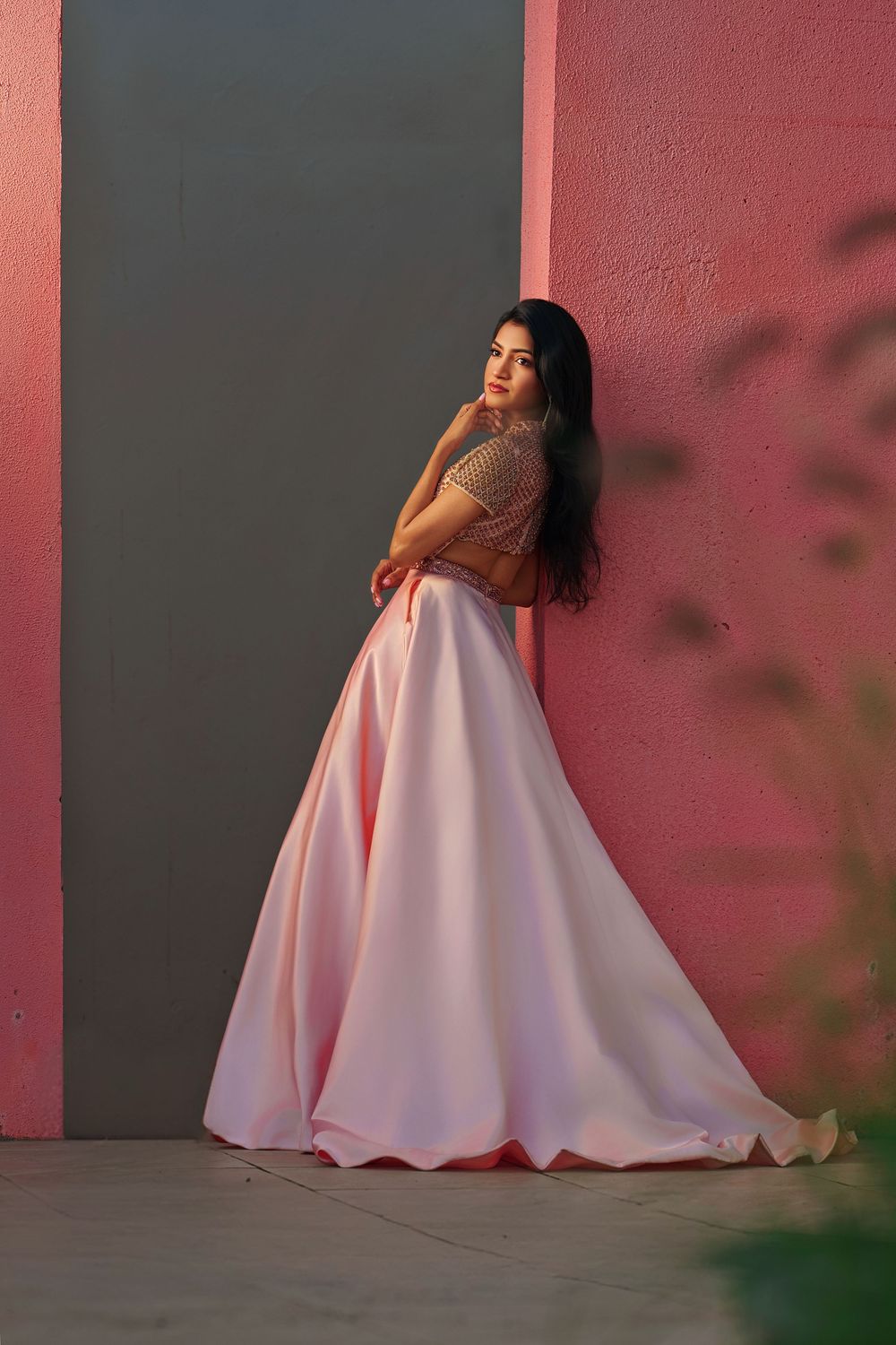 A person in a flowing white dress poses dramatically against a pink wall in a multi-panel artistic photo series.