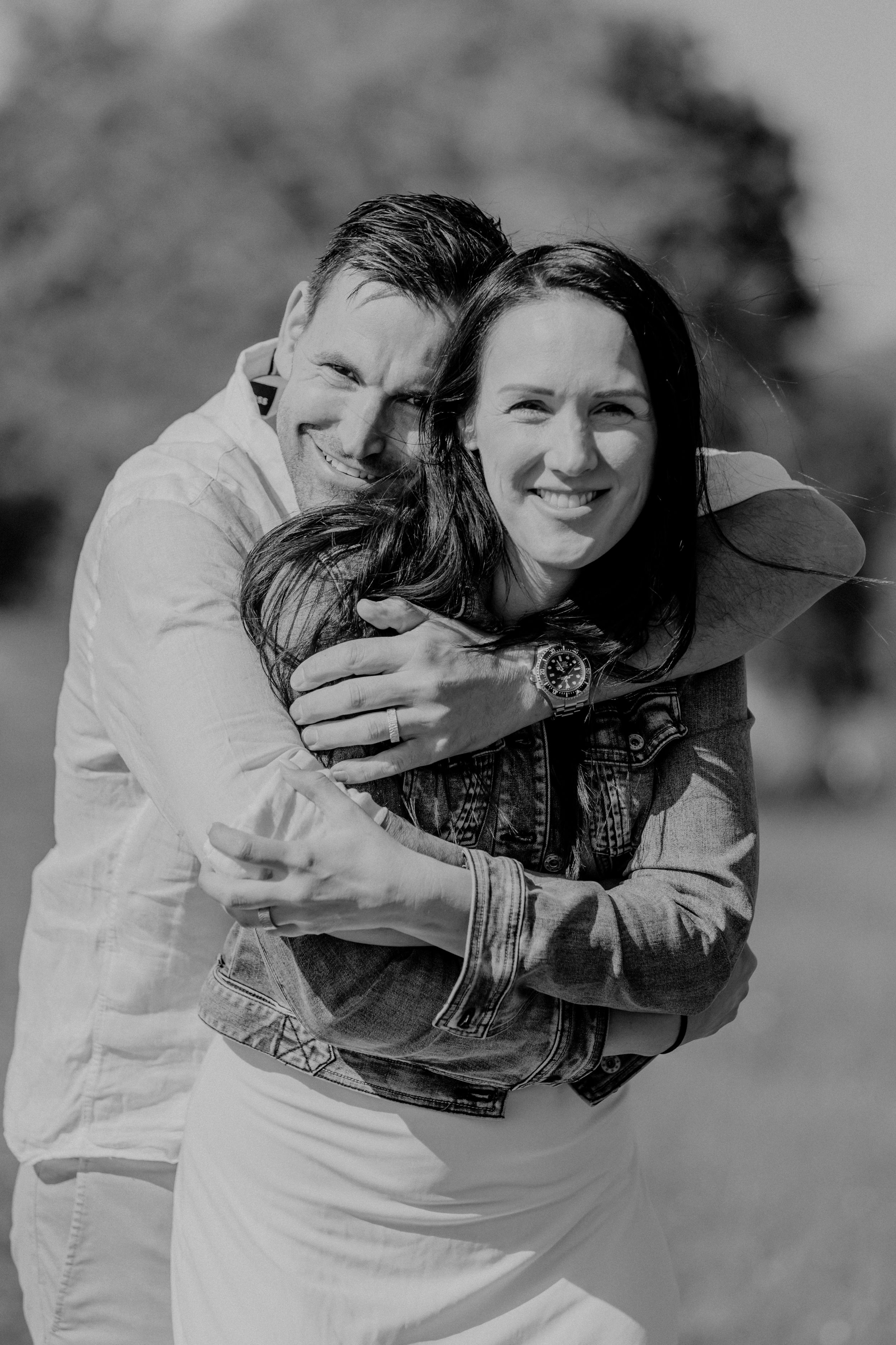 Joyful black and white portrait of couple embracing outdoors.