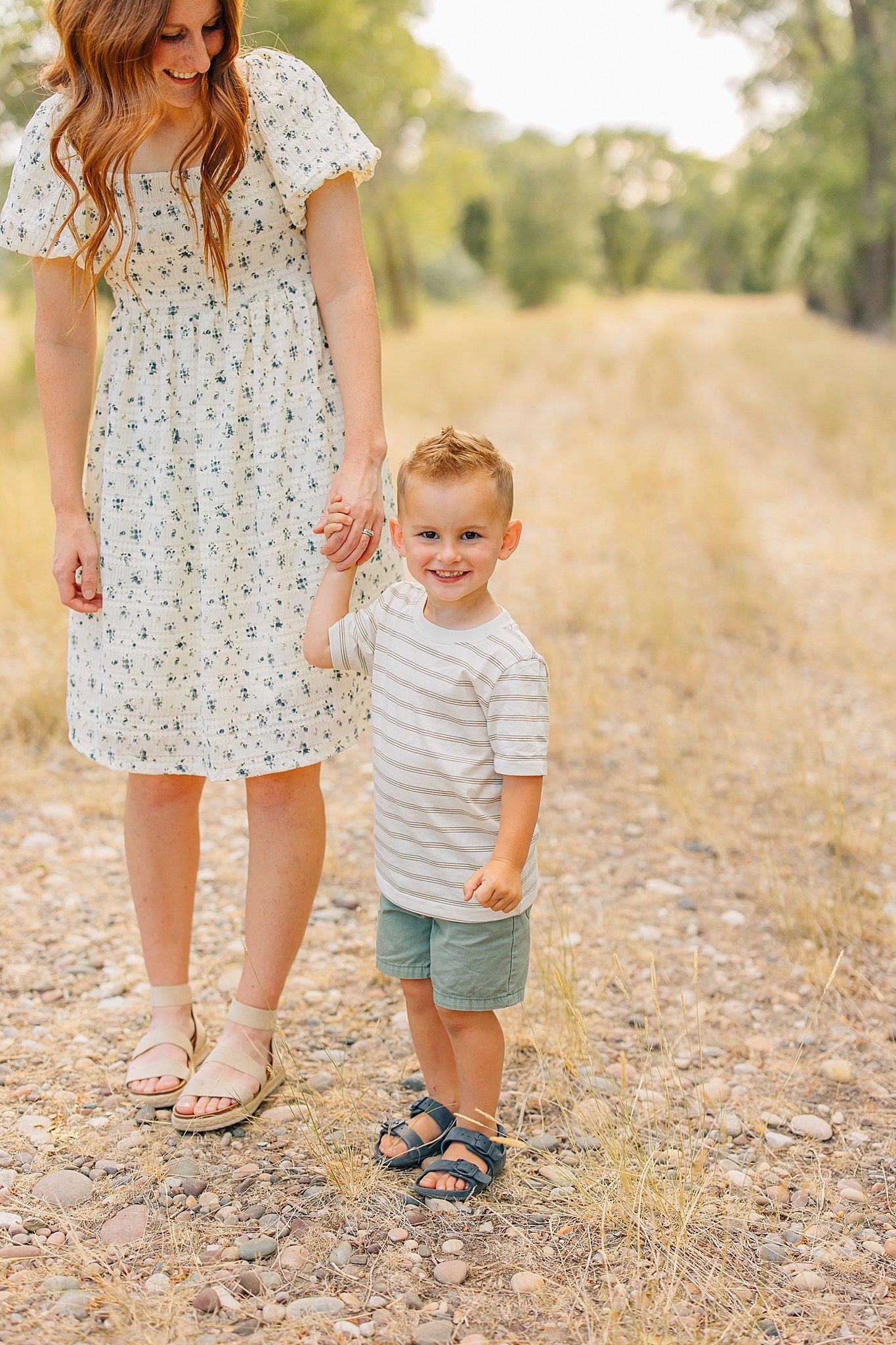 Close-up shots of feet walking together on a gravel path during a sunny summer day in nature.