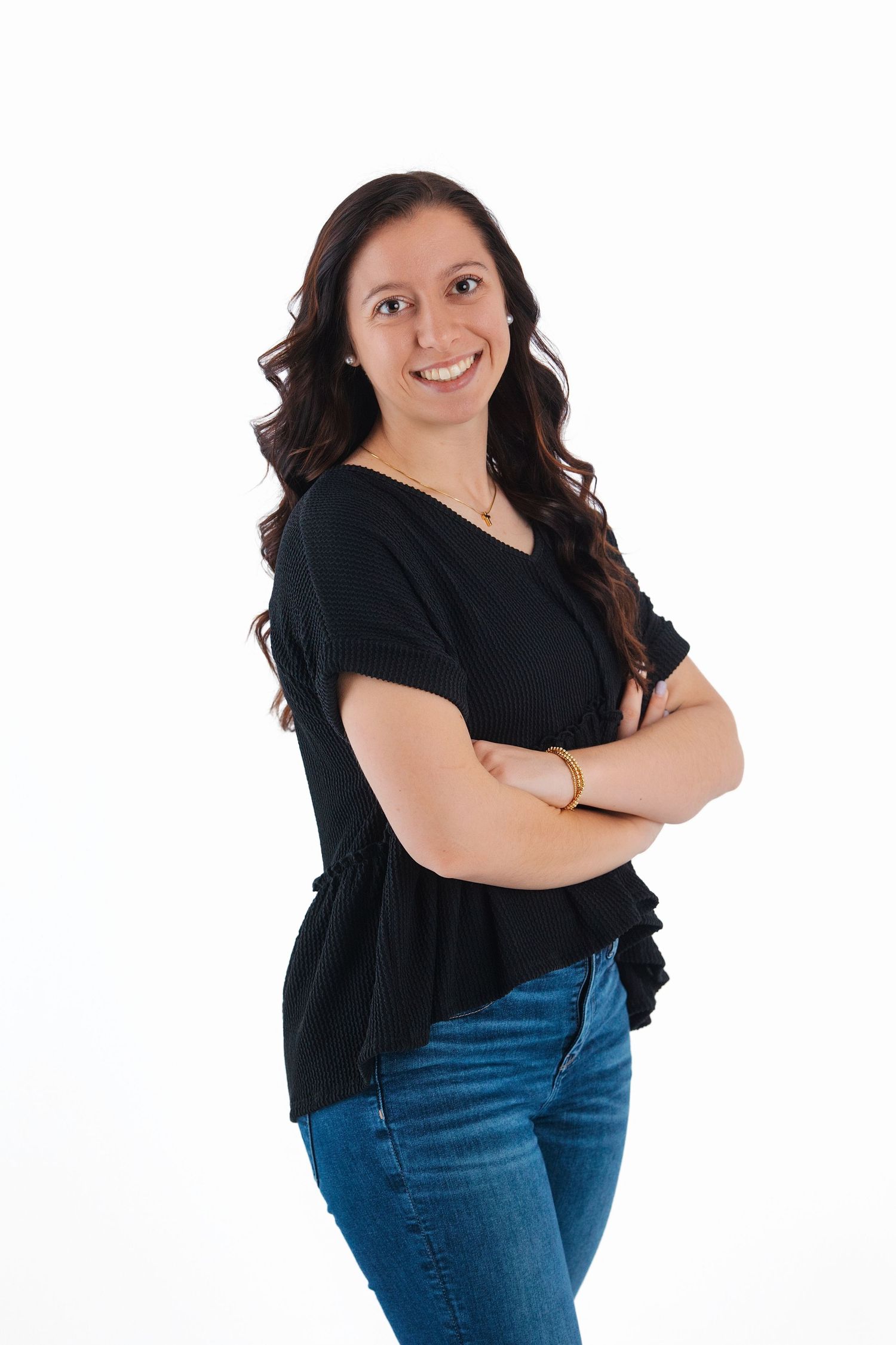 Person in black top and blue jeans strikes four different casual poses against white background.