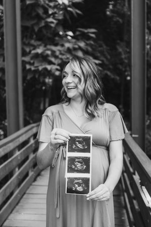 Black and white photos show someone joyfully displaying ultrasound images on a wooden walkway.