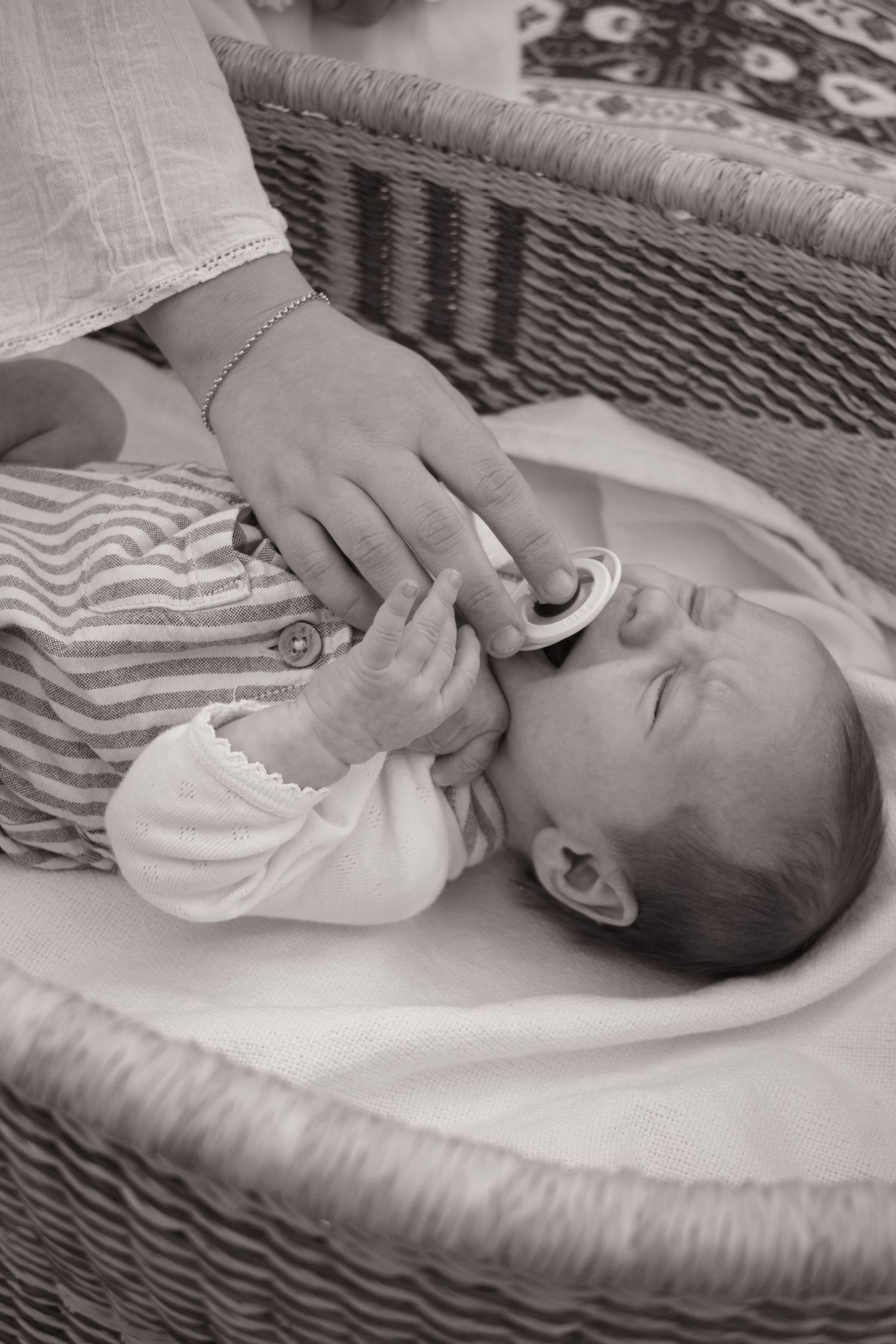 Newborn baby in Moses based crying as mum gives Dummy during a newborn photoshoot Maitland NSW