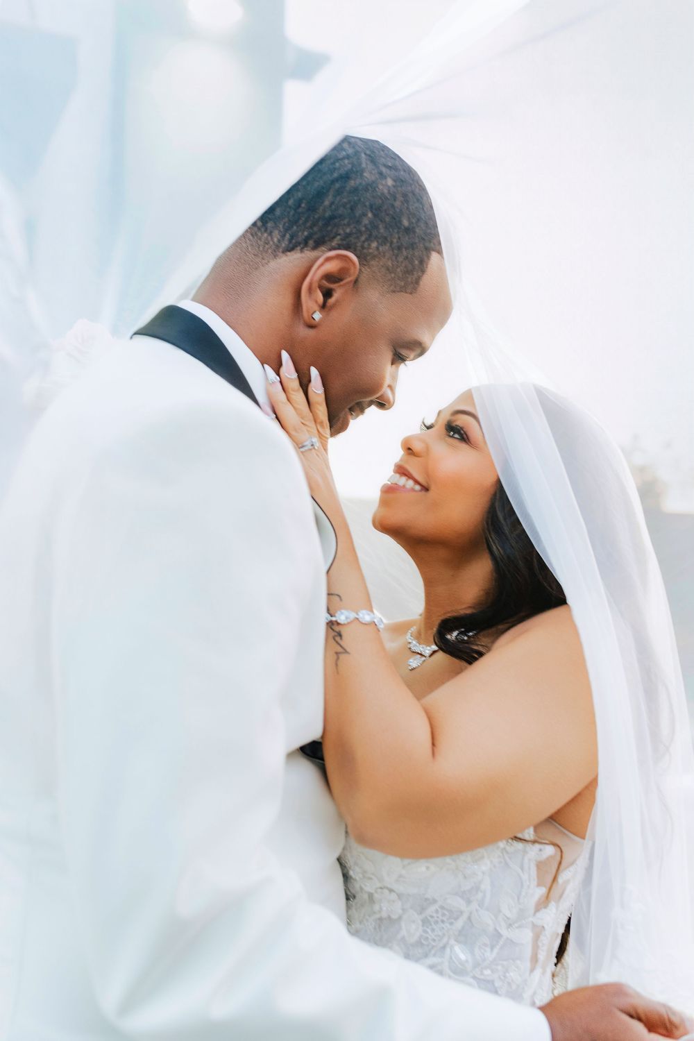 Intimate wedding portrait of a couple sharing a tender moment against a soft light background.