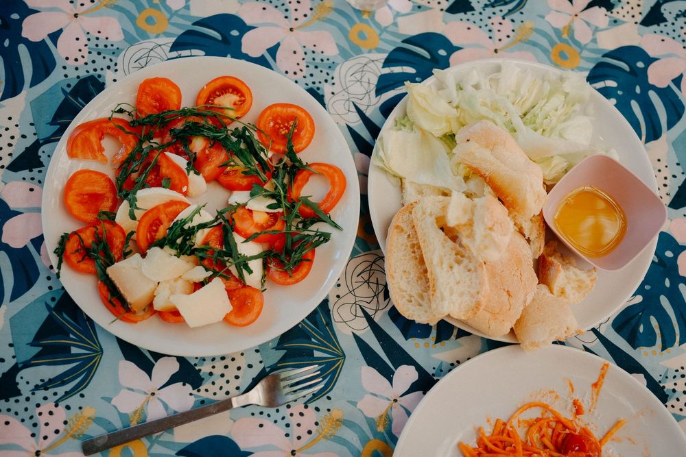 Fresh seafood dishes with colorful garnishes arranged on patterned plates.