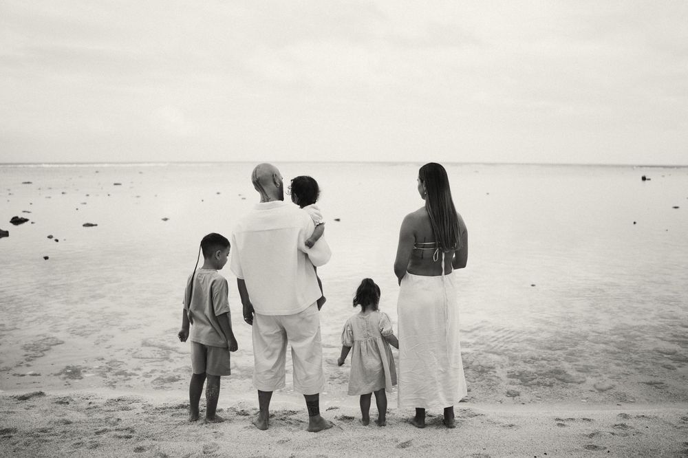 A series of black and white photos showing people walking along a misty beach shoreline.
