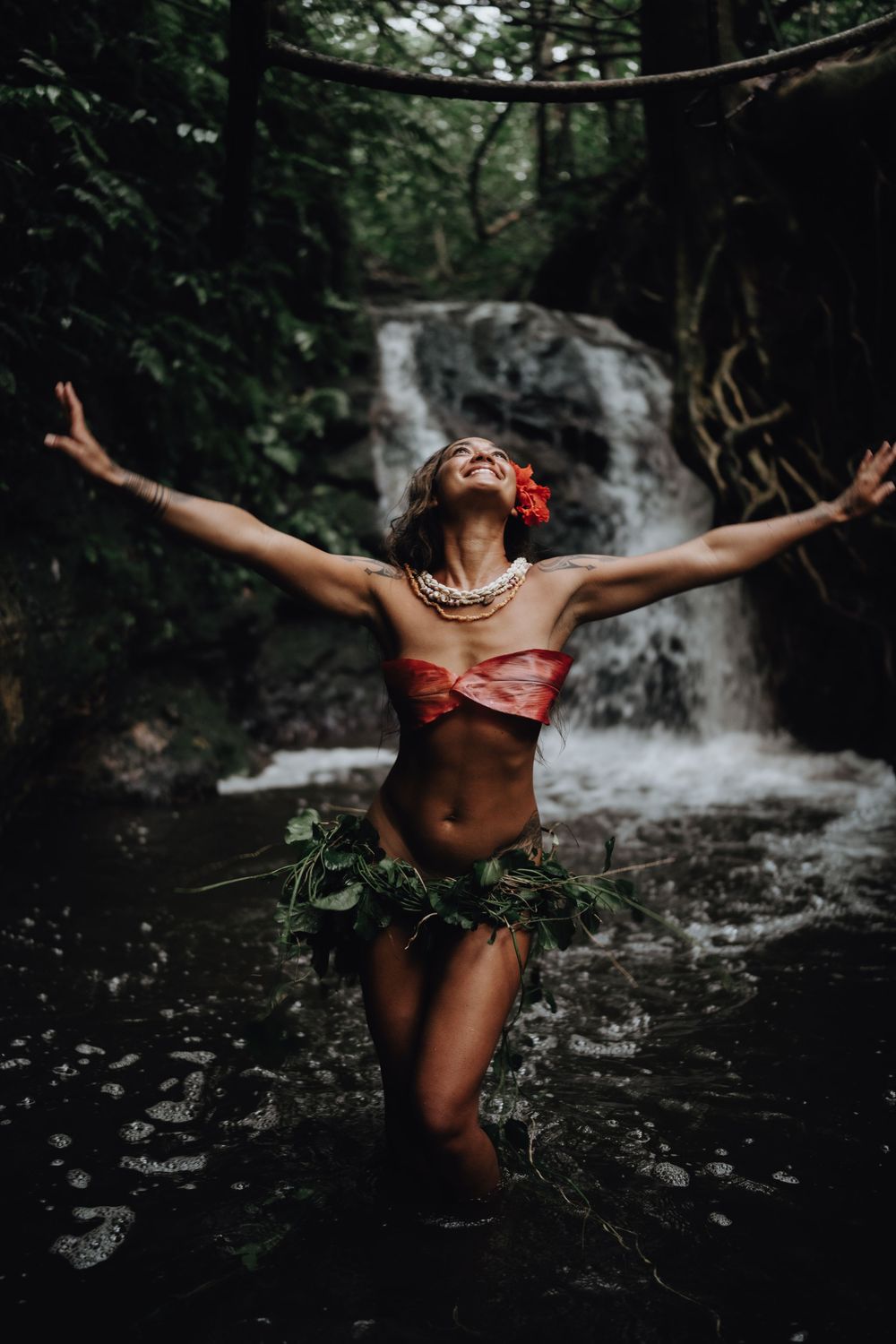 A sequence of artistic silhouette shots showing a dancer performing graceful movements near a forest waterfall.