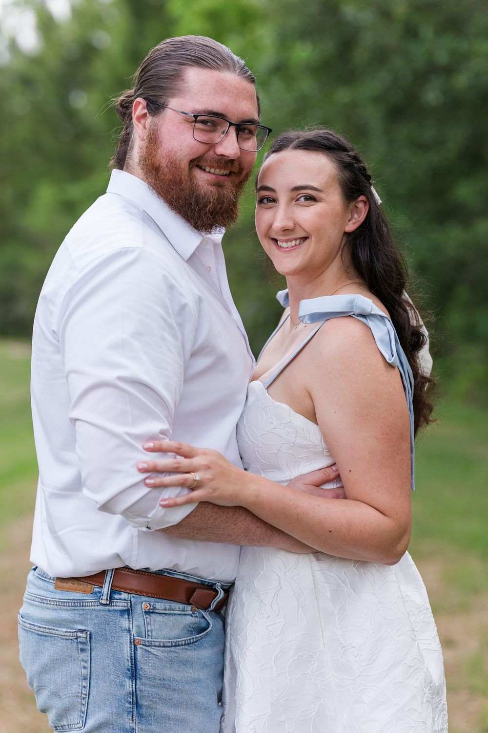 A couple embraces and laughs together outdoors in a series of candid moments against a green natural background.