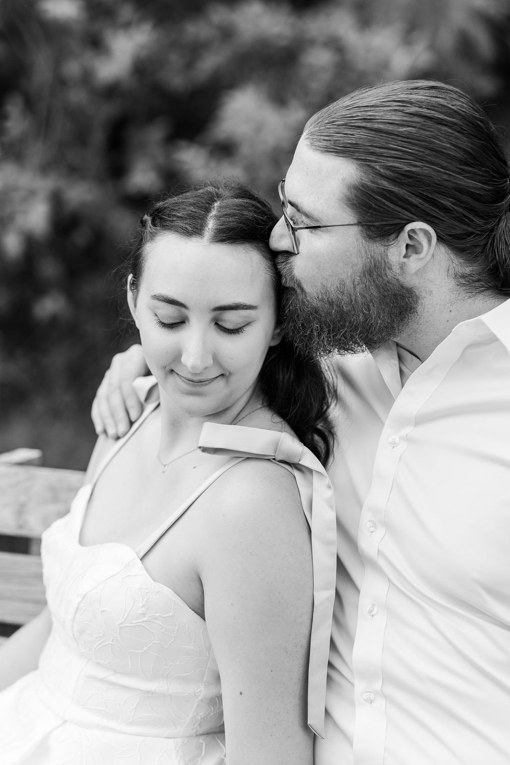 Intimate black and white portrait series of a couple sharing tender moments outdoors.