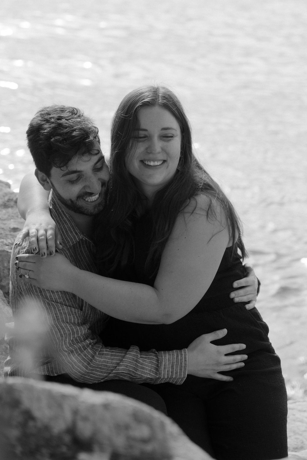 A black and white photo series showing a couple embracing and laughing together outdoors.