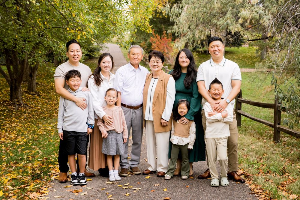 Extended family group portrait in autumn park setting.