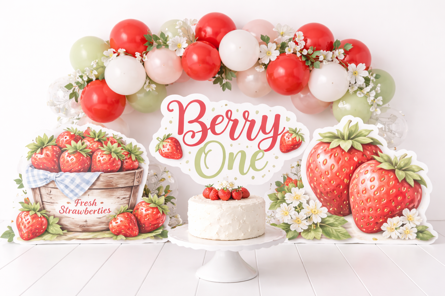 Berry One strawberry first birthday cake smash backdrop with balloon garland and strawberry cutouts.