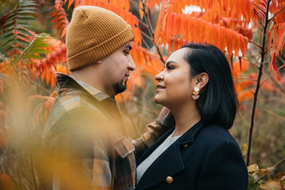 A couple shares a romantic moment surrounded by vibrant Fall foliage during engagement session in Chicago Lincoln Park