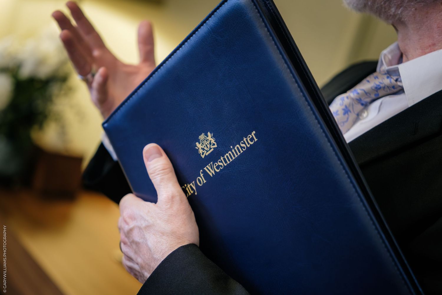 Close-up of a person holding a navy blue City of Westminster official folder with gold embossed text and crest.