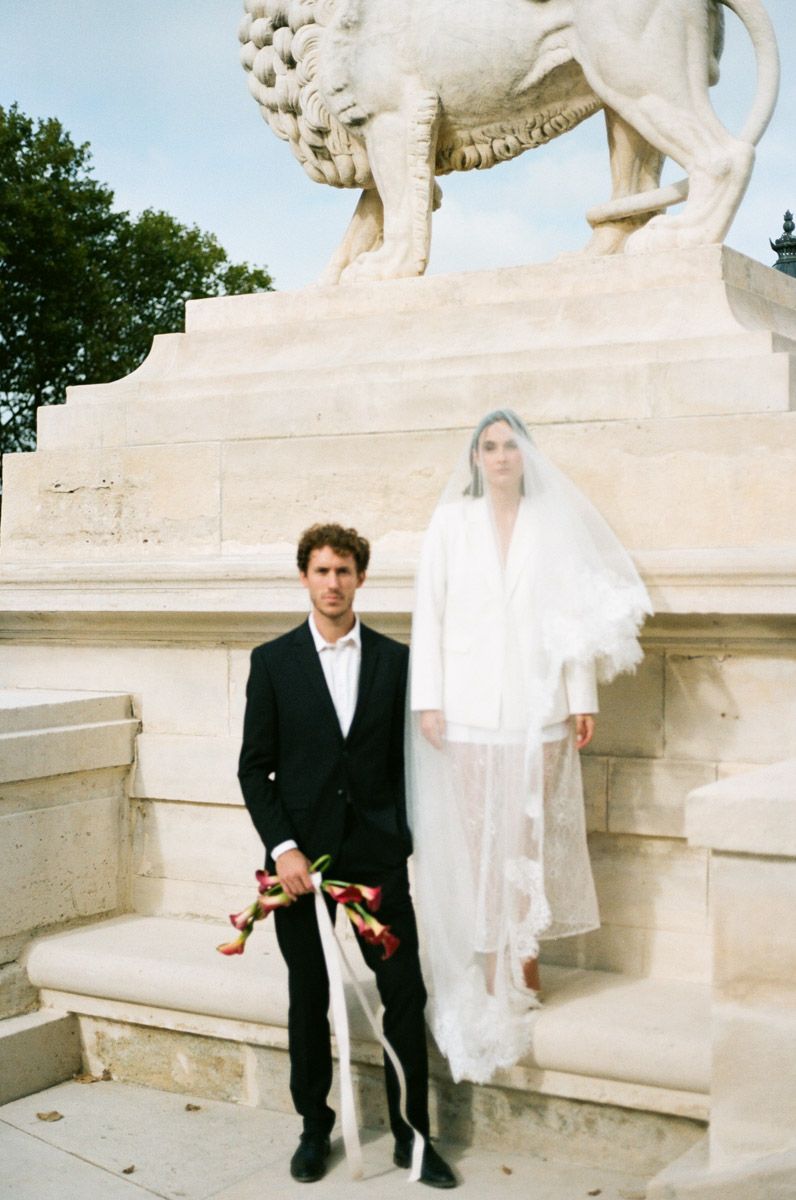 Couple walking through Tuileries Garden Paris on wedding day, film photography. Paris editorial wedding photography.