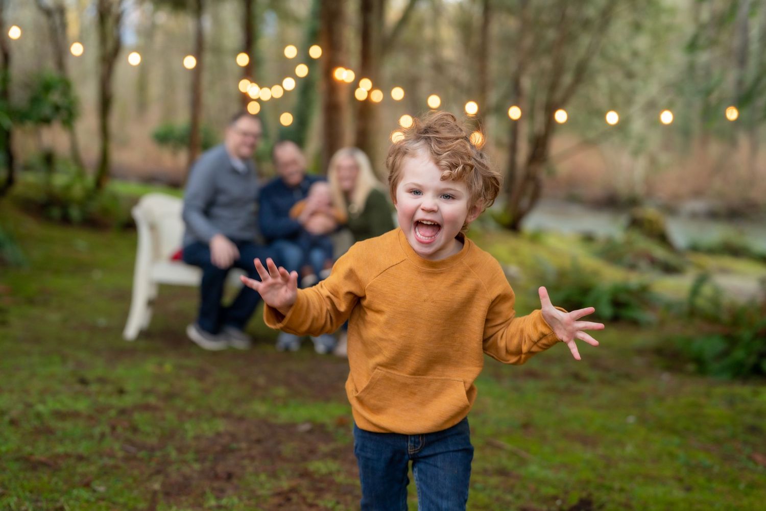 Children playing and running through garden with string lights at dusk.