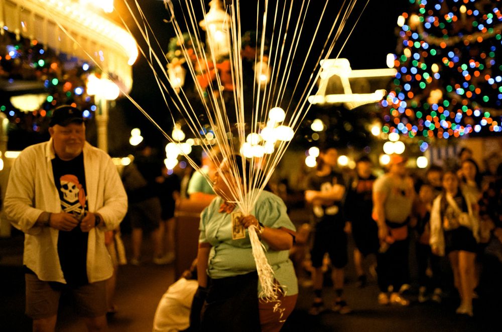 Crowd gathering at night with glowing light-up balloons creating a magical atmosphere.