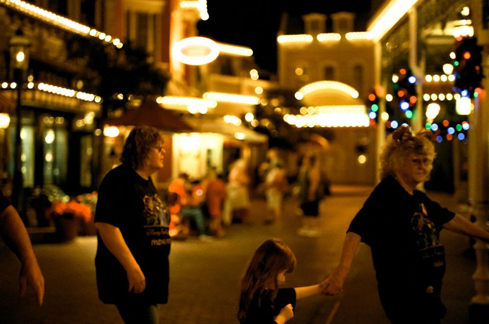 Evening street scene with holiday lights and pedestrians walking along Main Street.