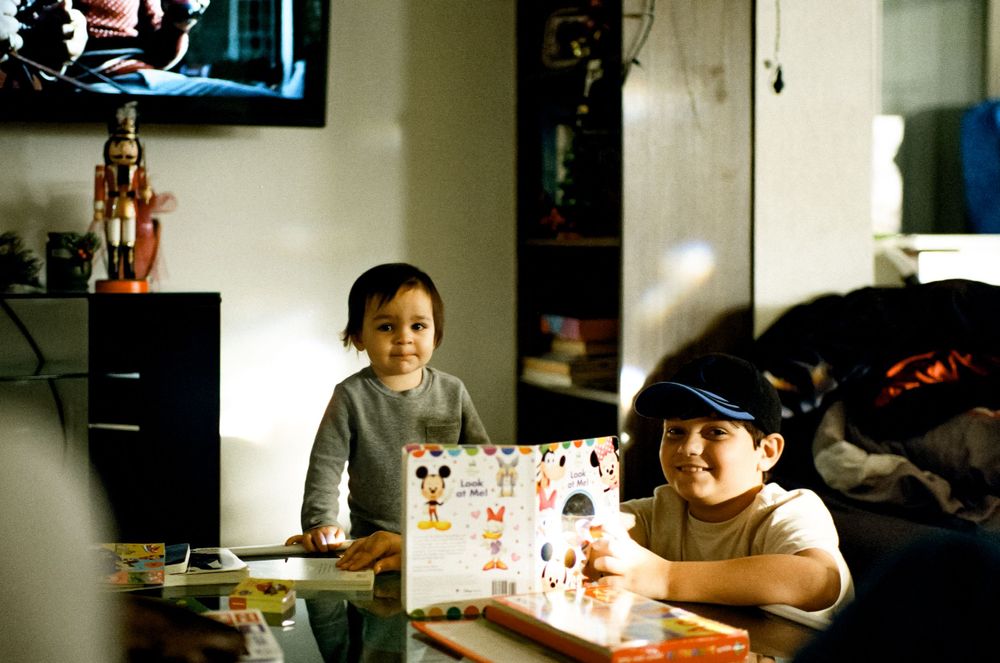 Children seated at a table with art supplies and drawings.