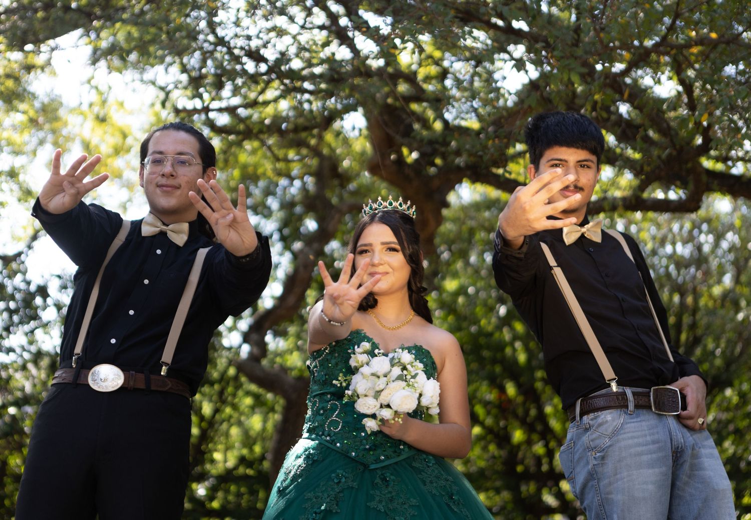 Three people pose dramatically outdoors with animated expressions.