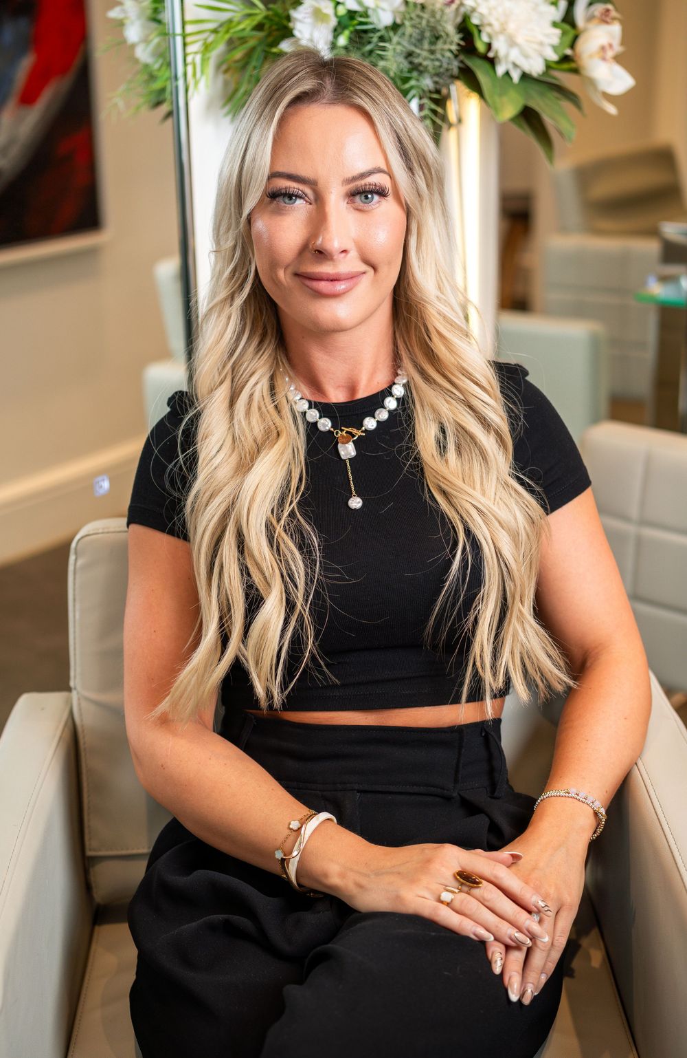 A series of lifestyle portraits showing someone seated in a black outfit against a neutral interior background.
