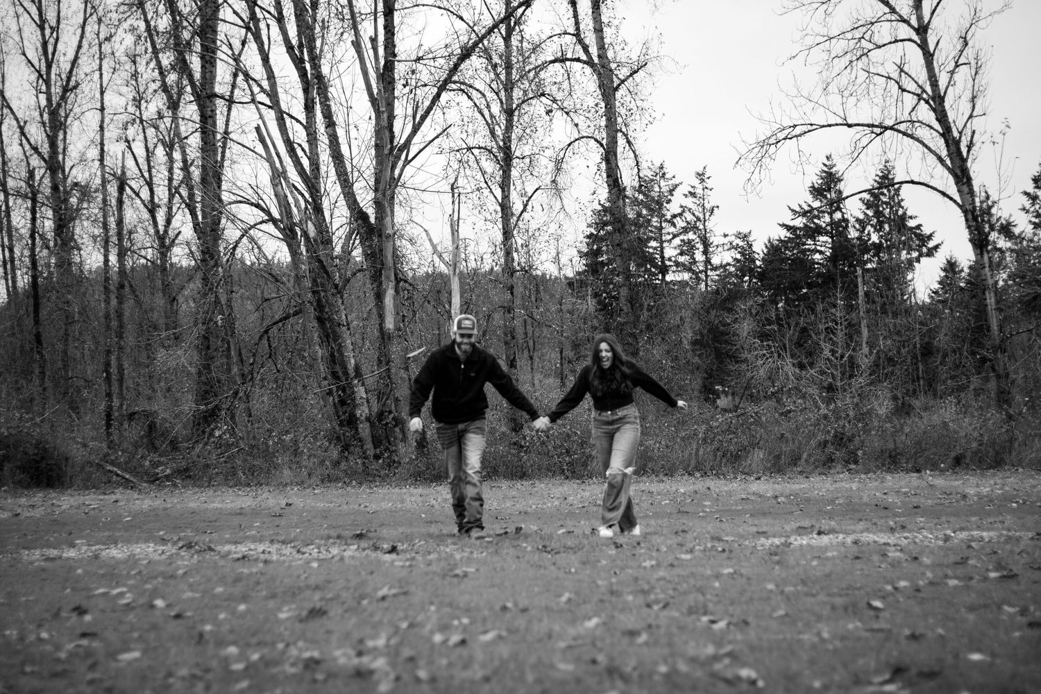 black and white image of blurred couple holding hands and running toward camera