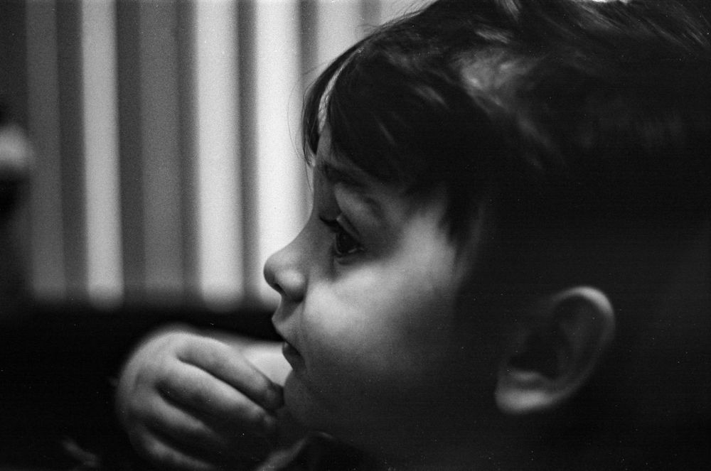 A side profile view of a child in contemplative black and white.