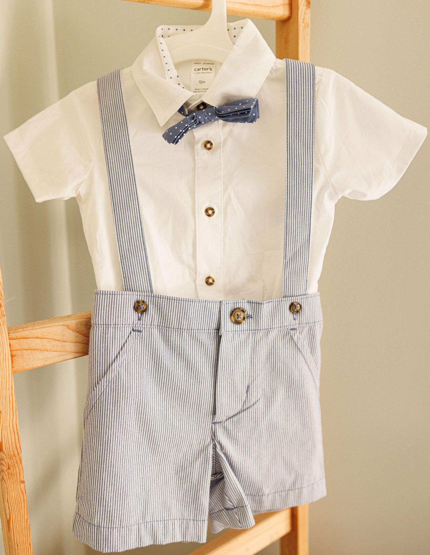 Adorable vintage-inspired baby boy outfit with white button-down shirt, blue striped suspender shorts and matching bowtie.