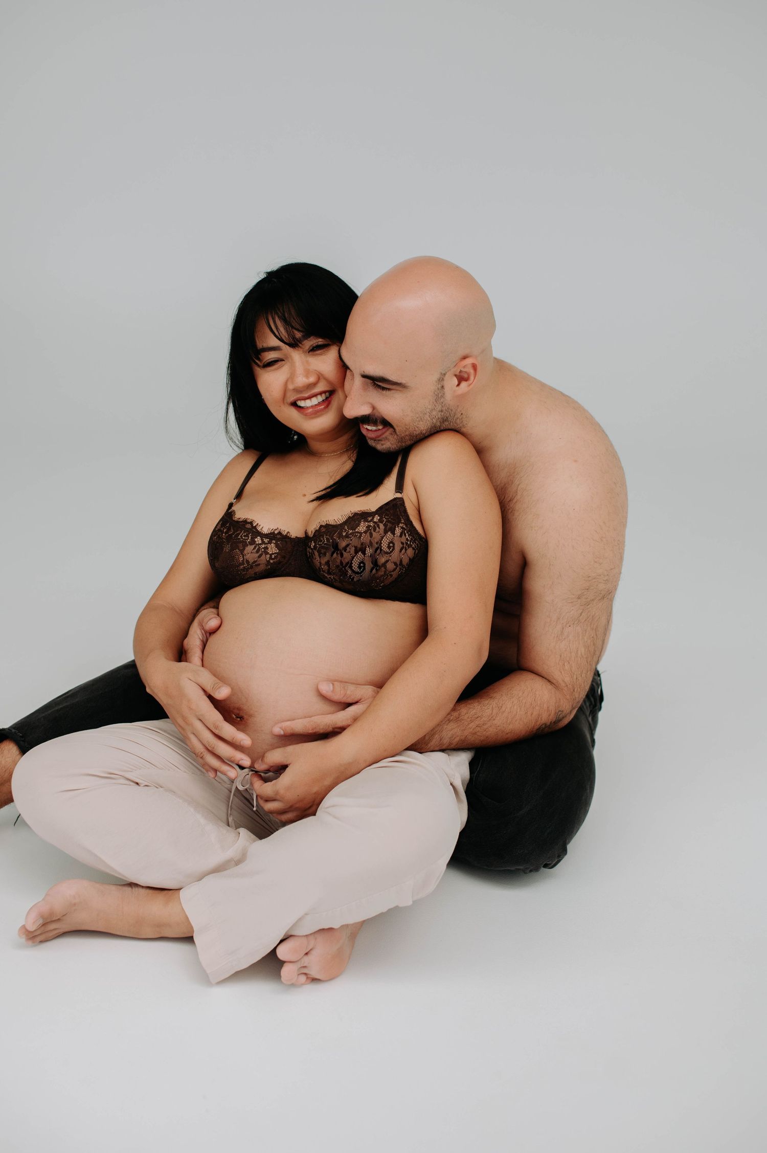 Joyful maternity portrait of expecting couple sharing tender moment together.