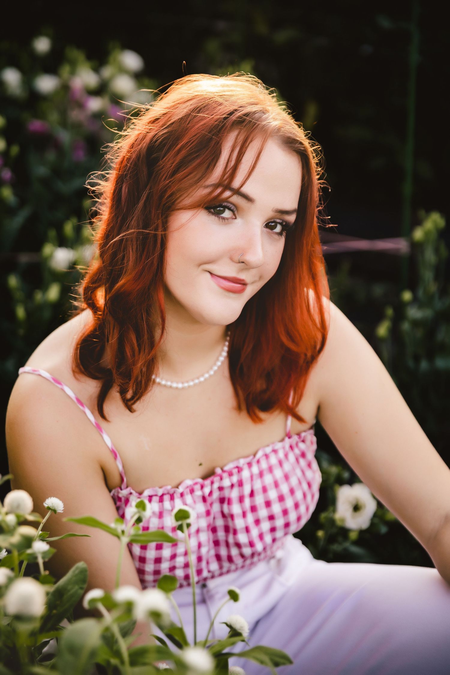 Senior photo session for teen girl surrounded by flowers in an  outdoor location, captured by Urso Photography.