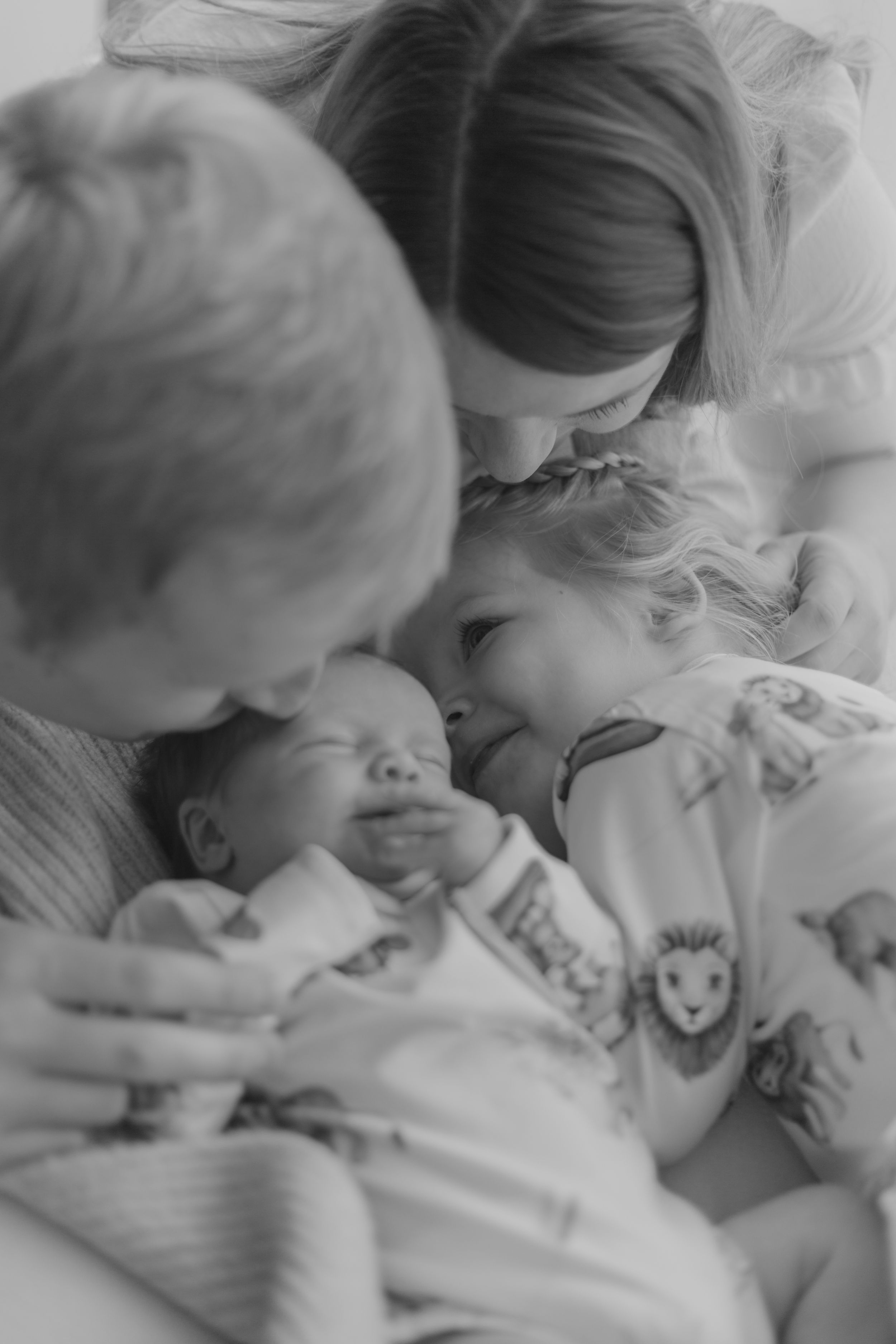 Mum dad and older sister with newborn and dog