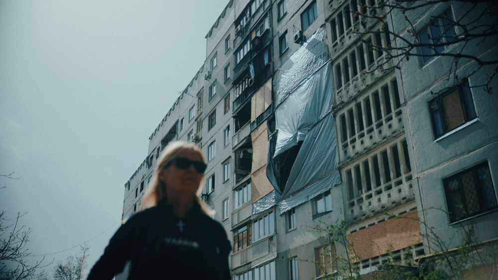 A damaged apartment building with exposed walls and debris visible.