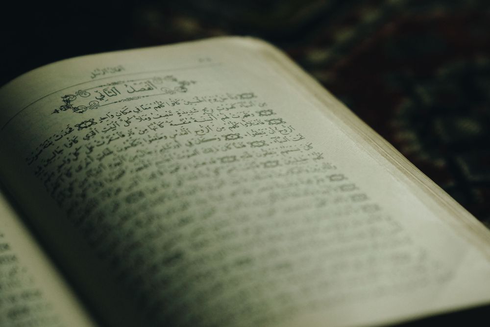 An open book with handwritten text on aged pages in dramatic lighting.