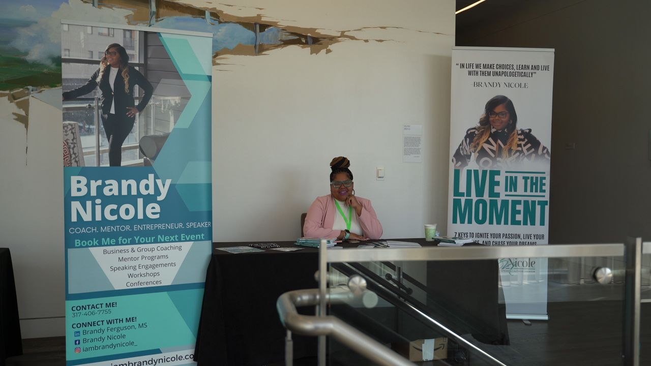A DJ setup with promotional banners and event posters in an indoor venue.
