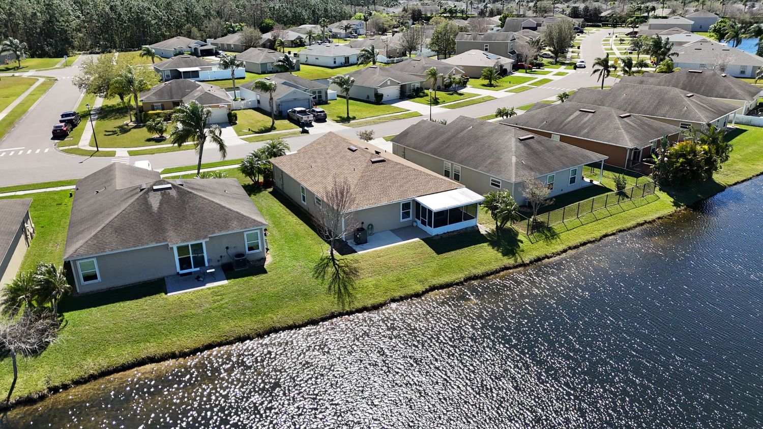 Waterfront homes with well-maintained lawns along a scenic lake in a residential neighborhood.