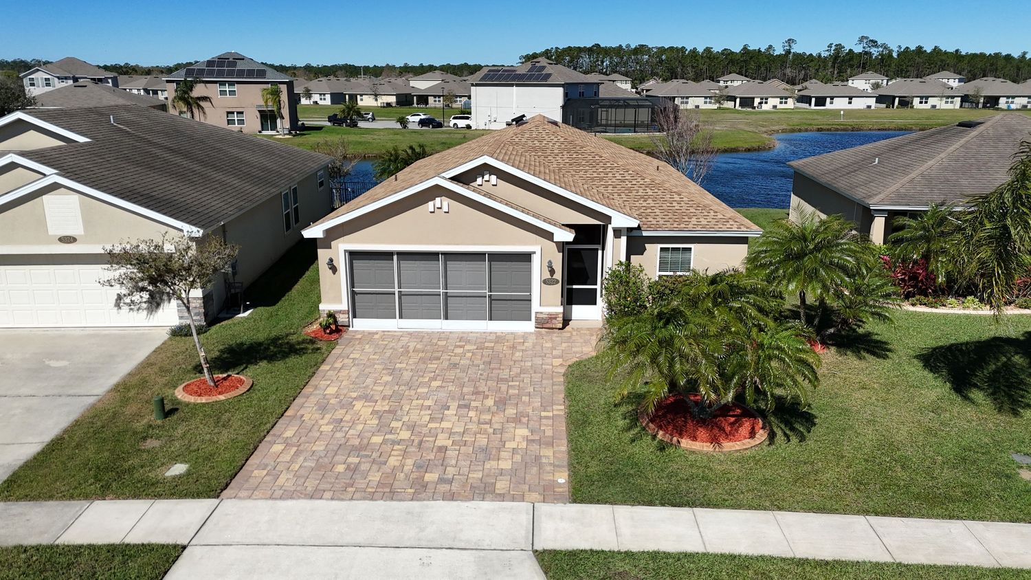 Aerial view of beige and brown roofed houses in a planned community with paved driveways.