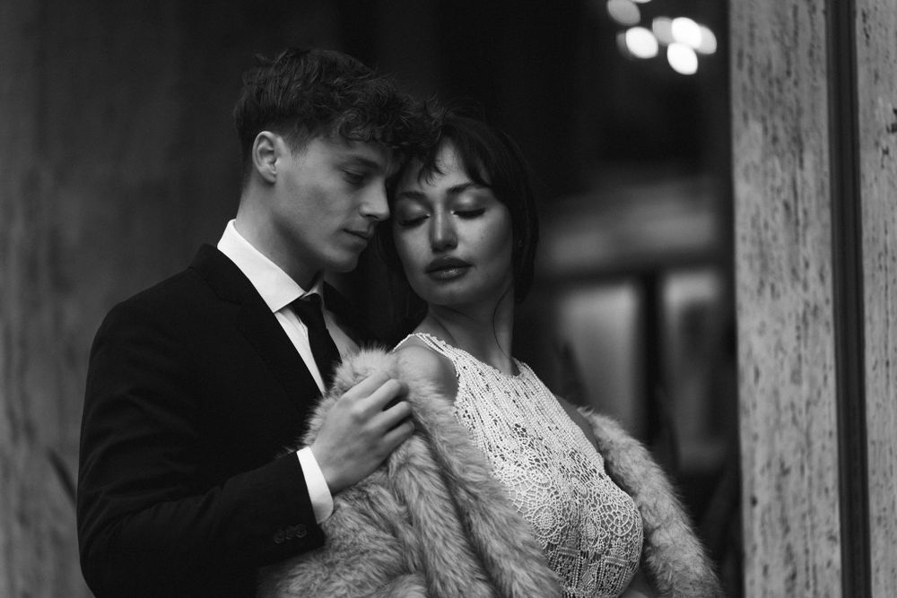 Intimate black and white portrait of couple embracing in vintage-inspired formal wear. Next day wedding photography.