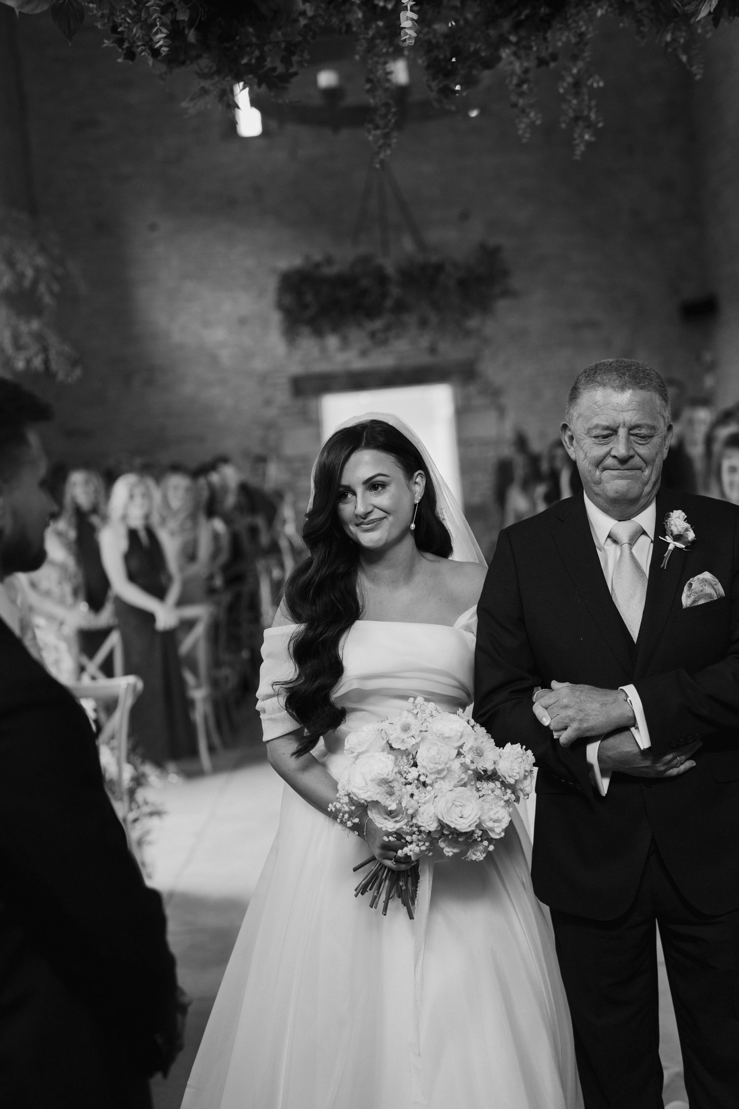 bride and dad walking down aisle during wedding ceremony at yardspace old gore in cirencester